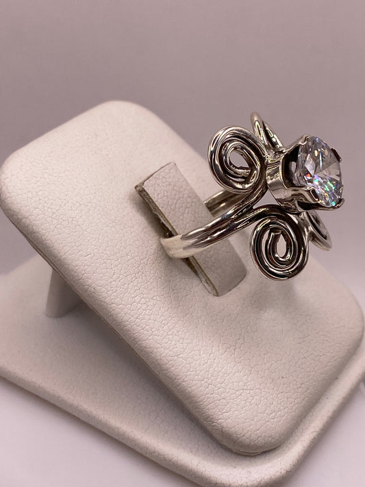 Anillo solitario con espirales artesanales y circonia brillante visto de frente