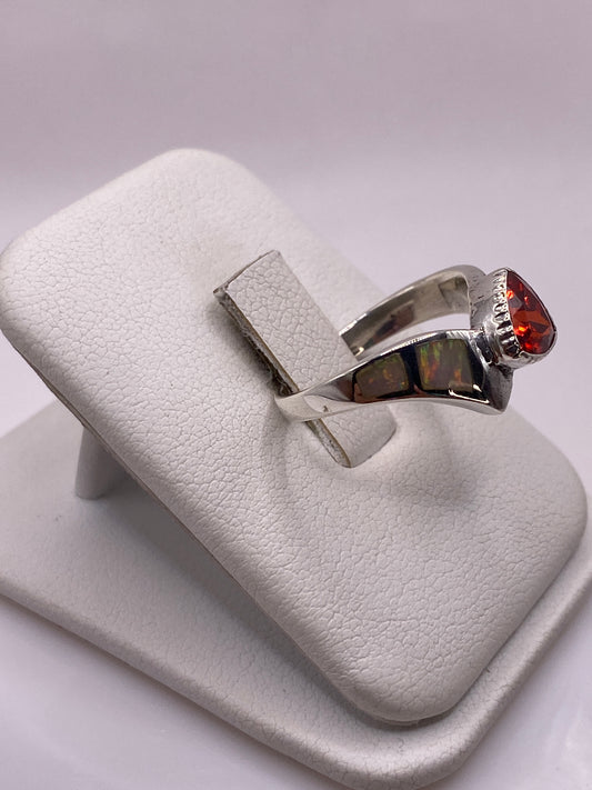 Detalle lateral del anillo mostrando el engaste de circonia roja y blanca
