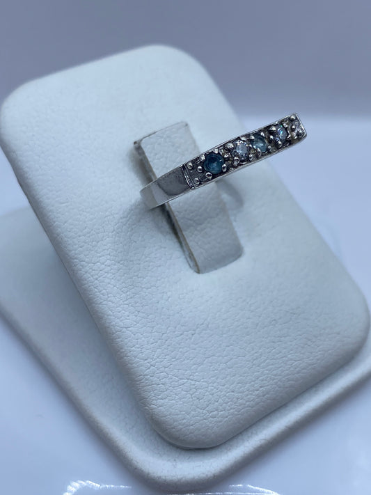 Anillo solitario de plata .925 sobre dedo, mostrando la circonia azul en luz natural
