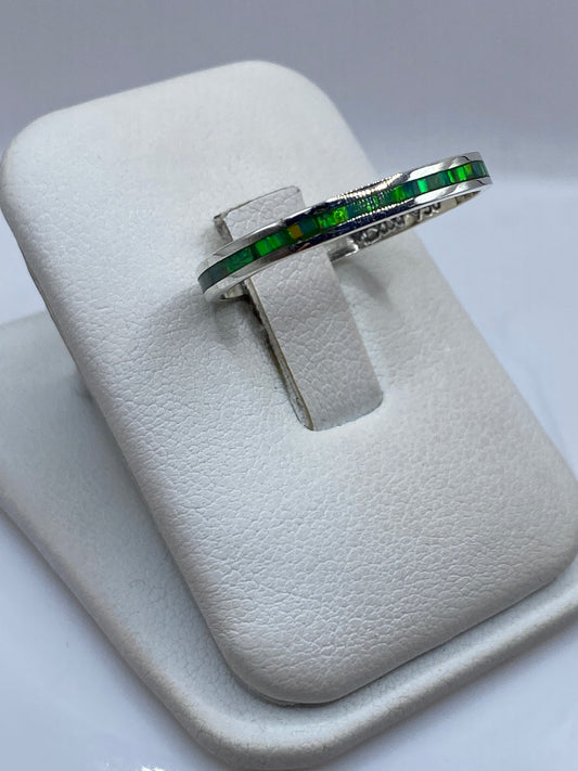 Anillo minimalista unisex en plata pura mostrando el brillo verde del ópalo de fuego