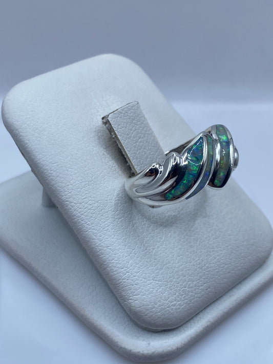 Detalle frontal del anillo ondulado mostrando el juego de color del ópalo