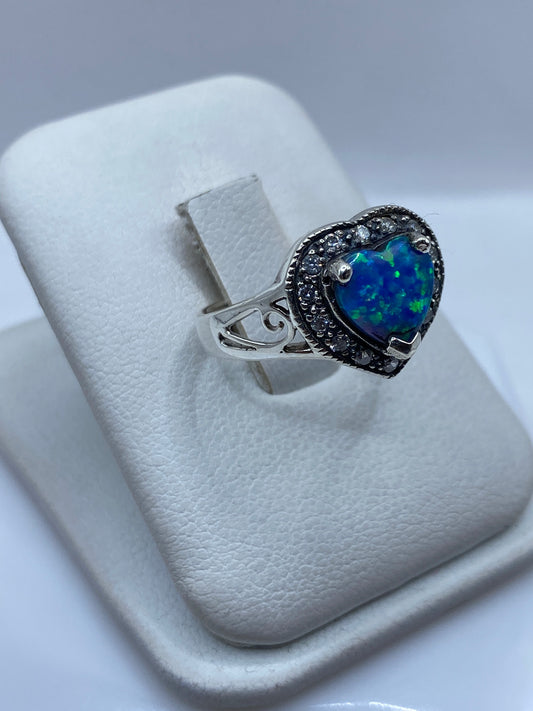 Vista frontal del anillo ópalo de fuego mostrando juego de colores azul y verde