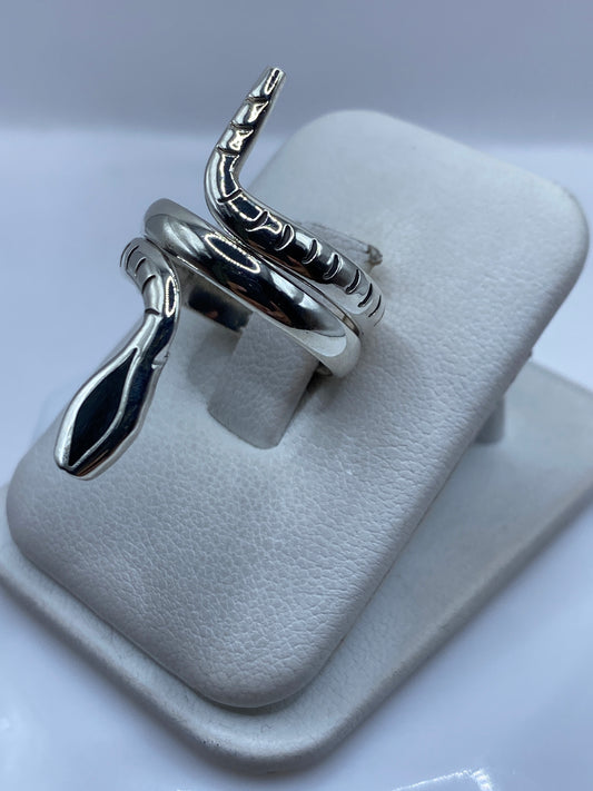 Detalle del anillo escultural de plata en forma de serpiente enroscada