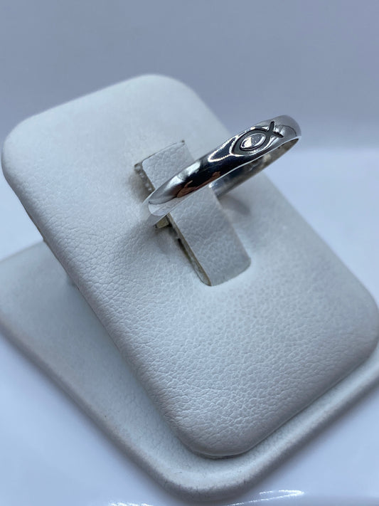 Anillo minimalista de plata .925 en el dedo de una persona, mostrando el pulido brillante