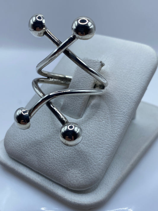 Anillo ajustable en la mano, mostrando la estructura geométrica de eslabones