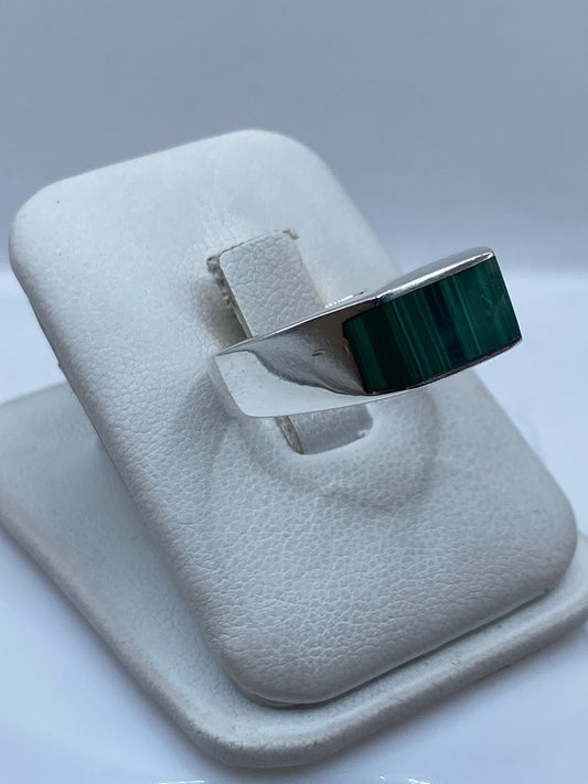 Anillo de plata malaquita verde en dedo de hombre, mostrando el peso y presencia