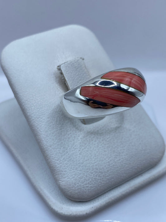 Anillo de coral y plata Taxco en el dedo, mostrando la faceta y el brillo del coral