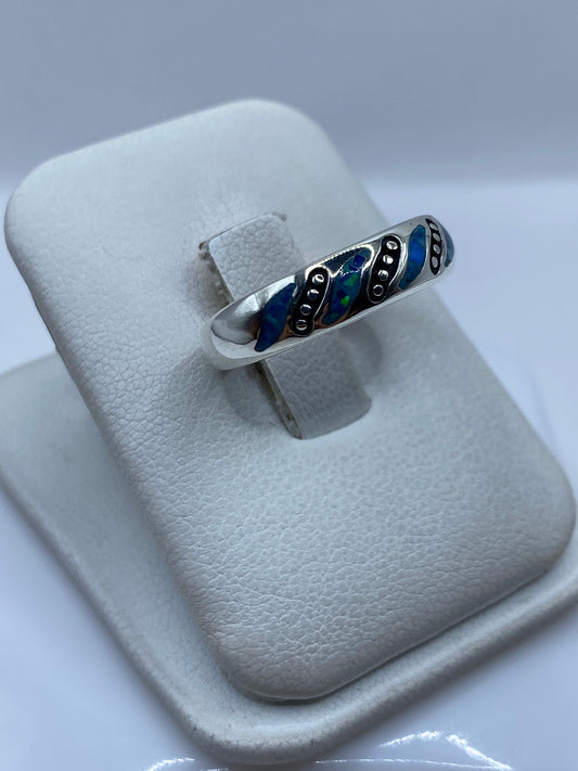 Detalle lateral del anillo mostrando la incrustación de la piedra azul y el acabado pulido