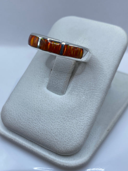 Vista lateral del anillo mostrando el engaste a mano del ópalo naranja en plata pura