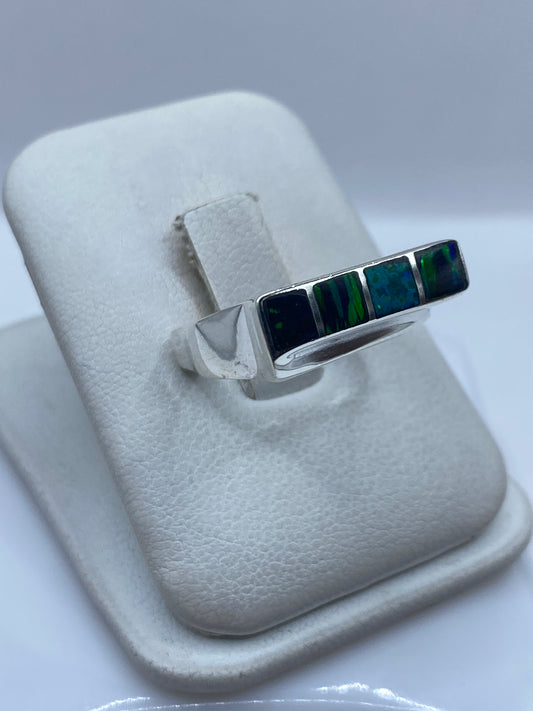 Detalle del Ópalo de Fuego azul con destellos verdes en el engaste de plata