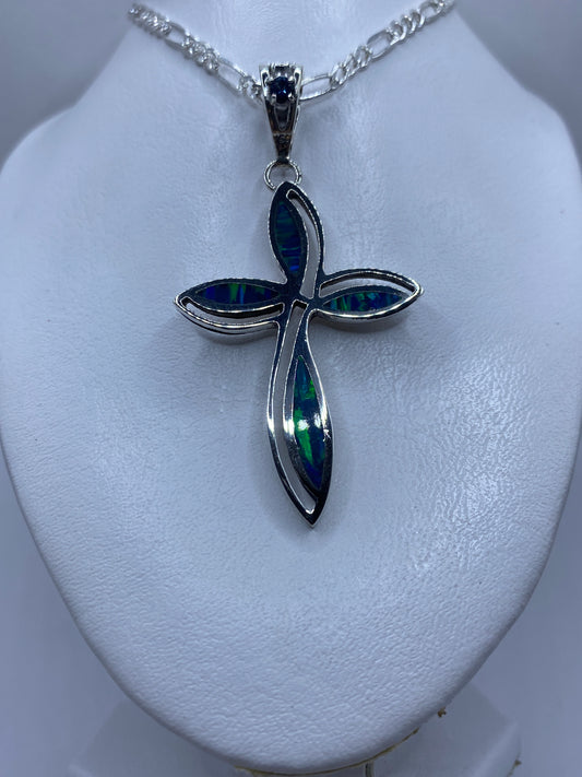 Cruz de plata .950 sobre metro para escala, mostrando 7.1 cm de largo