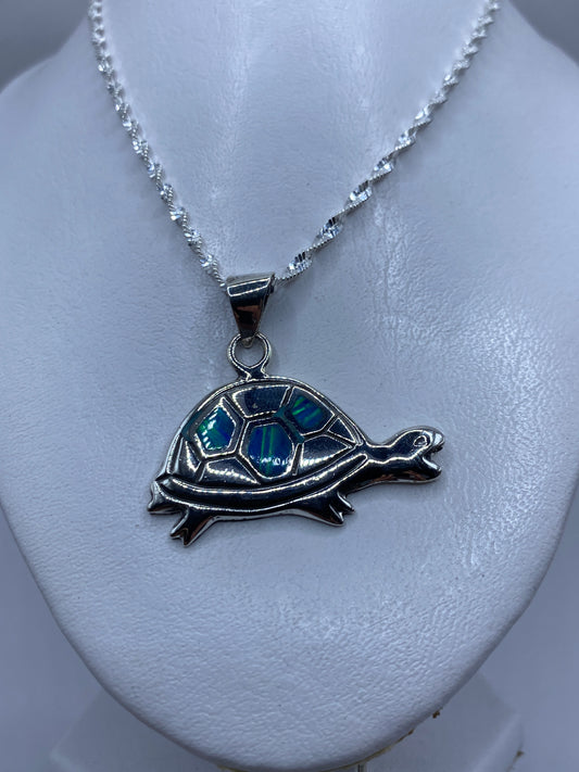 Detalle del ópalo de fuego azul engastado en el caparazón de la tortuga de plata