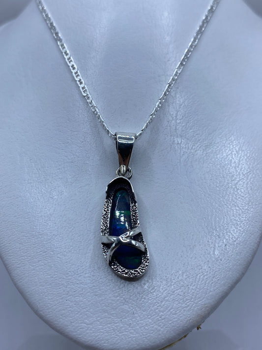 Ópalo de fuego azul con reflejos verdes y turquesas en la piedra, detalle de luz