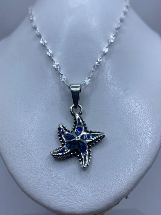 Detalle de la estrella marina mostrando los pétalos granulados y el ópalo azul en el centro