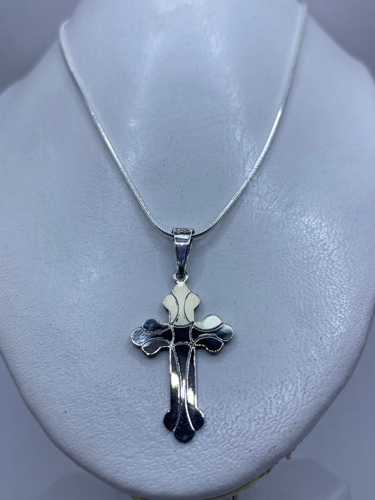 Cruz de plata fundida mostrando el acabado brillante y detalles texturizados