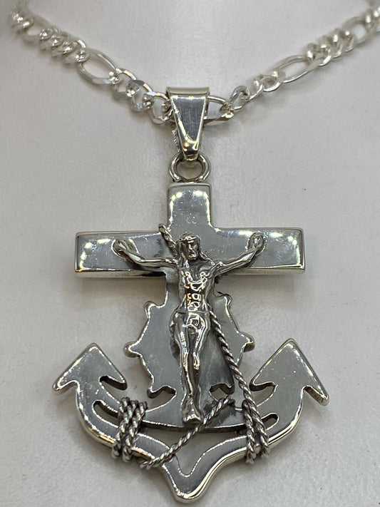 Detalle frontal del dije mostrando la cruz y los nudos marineros en plata pulida