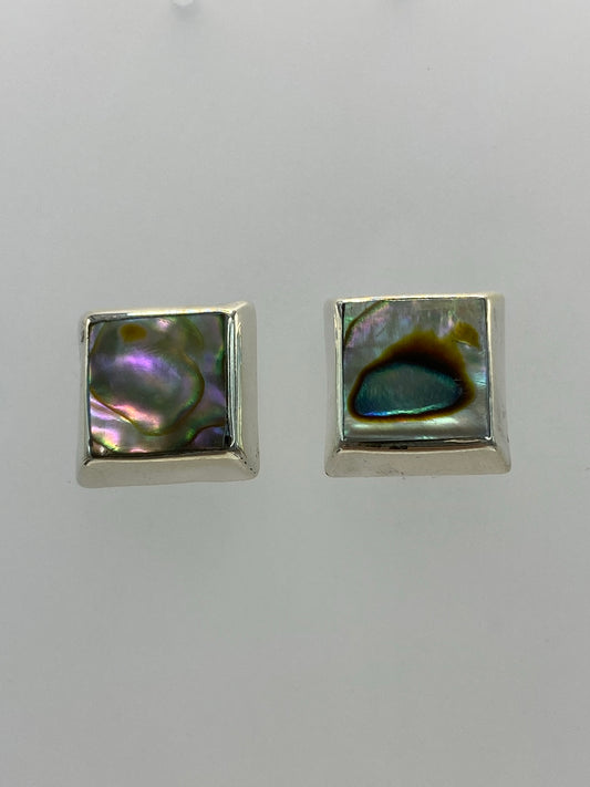 Detalle frontal de los aretes mostrando la incrustación de piedra y el pulido de la plata
