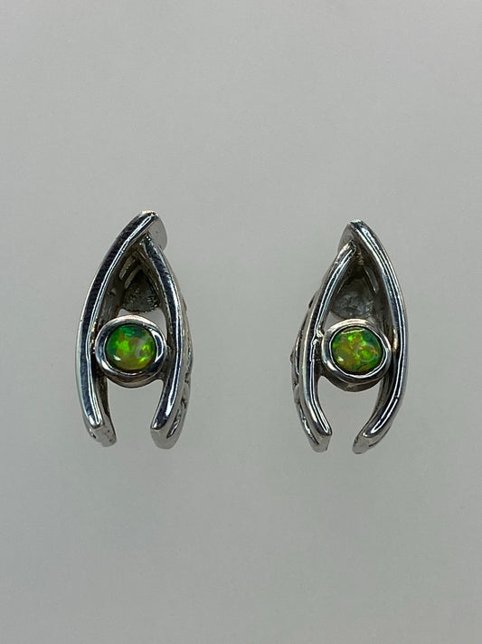 Detalle del ópalo de fuego verde en uno de los aretes, mostrando destellos y tonos cálidos