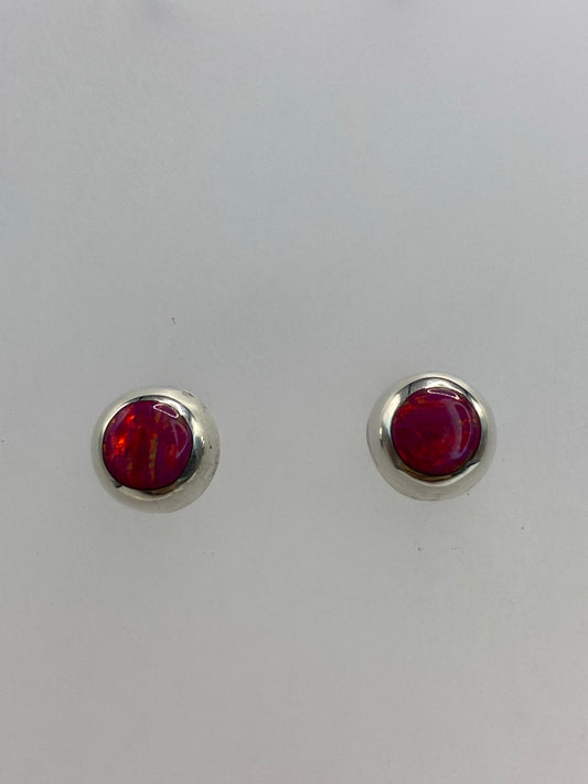 Detalle frontal de los aretes mostrando el brillo rosa del Ópalo de Fuego engastado