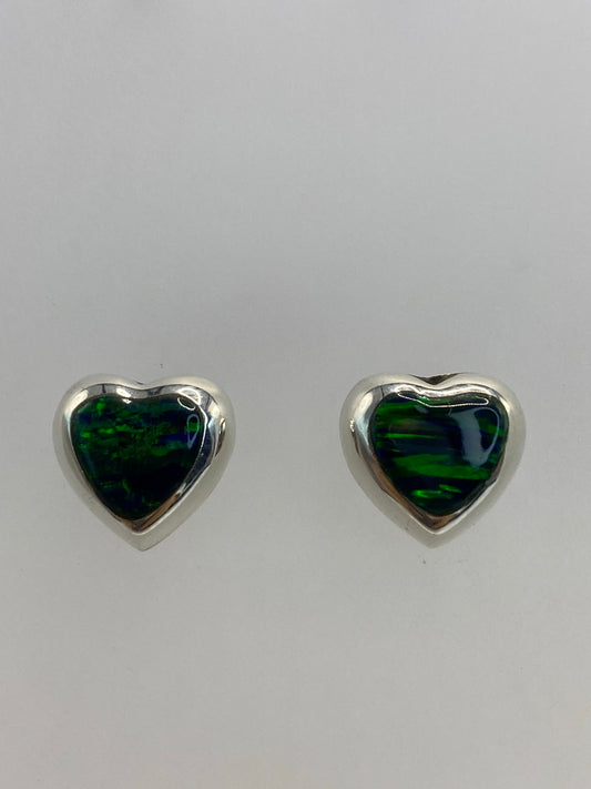Detalle cercano de los aretes mostrando el engaste de Ópalo de Fuego y el brillo verde