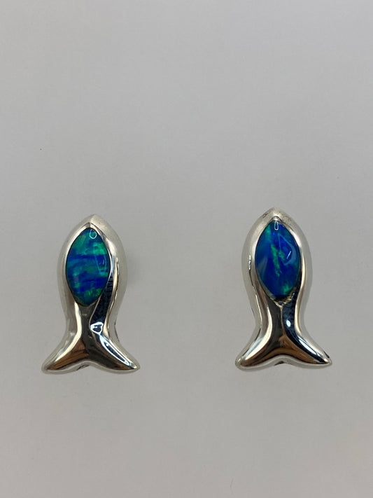 Detalle frontal de los aretes mostrando el color azul verdoso del ópalo y el brillo de la plata