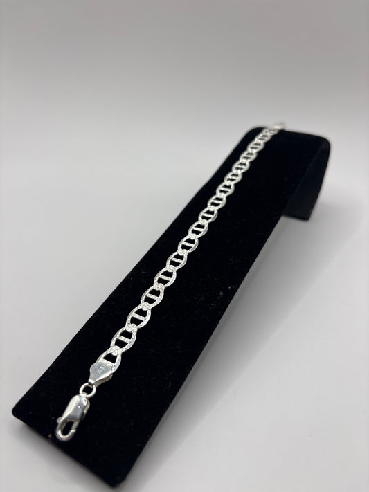 Detalle de los eslabones de la pulsera de plata, vista lateral sobre exhibidor
