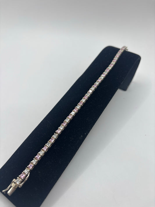 Detalle lateral de la pulsera mostrando el engaste de circonia rosa y el grosor de la banda