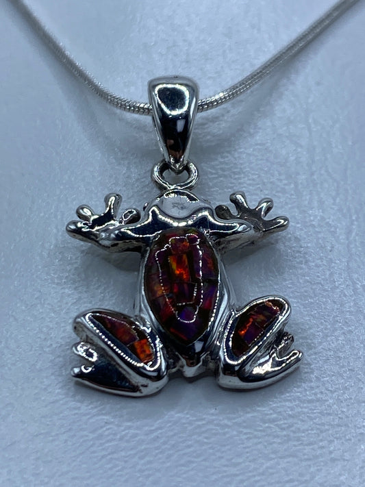 Detalle del ópalo de fuego multicolor en la rana de Taxco — brillos rojo, naranja y verde