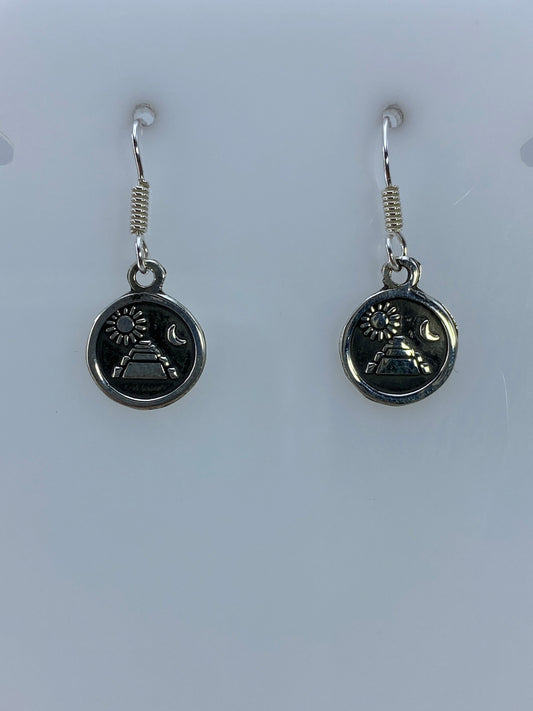Detalle del repujado en cada arete mostrando la pirámide, sol y luna