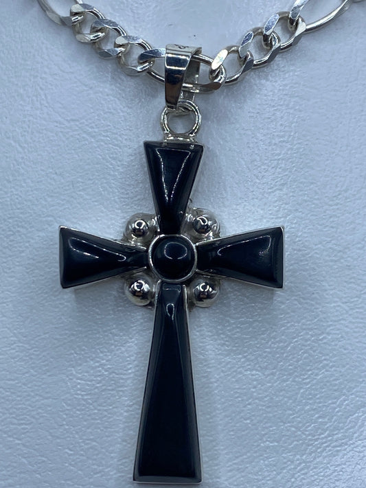 Detalle frontal de la cruz religiosa mostrando el ónix negro y los detalles esféricos