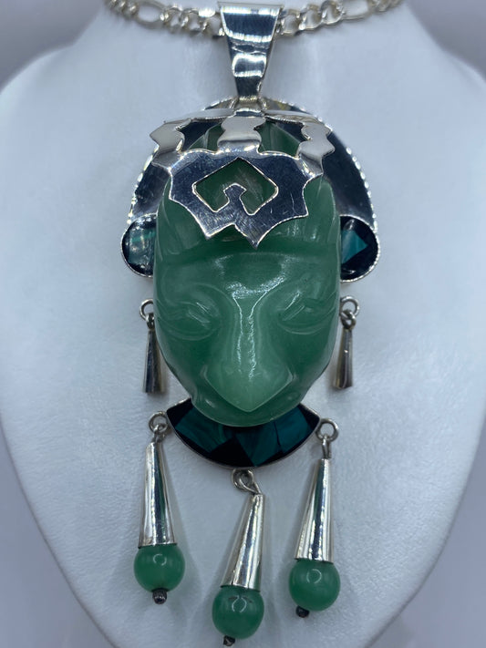 Dije de jade y malaquita en verde sobre cadena de plata, luciendo en el cuello