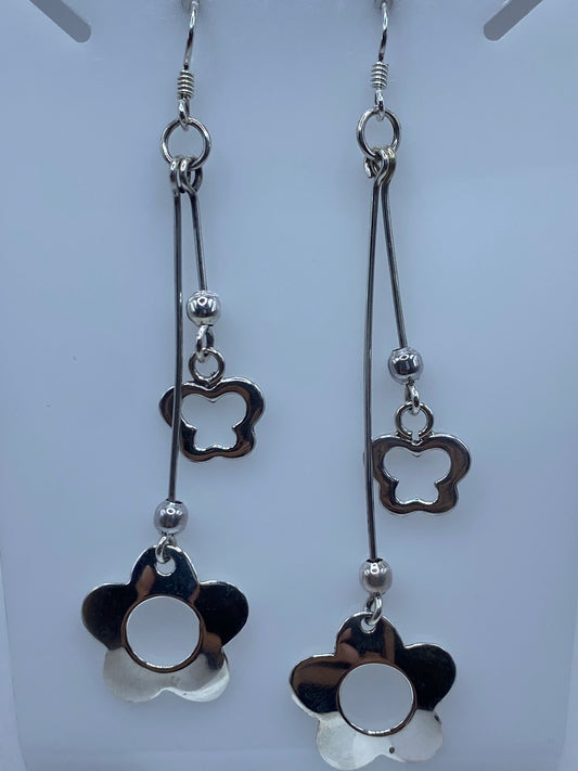Detalle de un arete mostrando la técnica de calado y los pétalos en volumen
