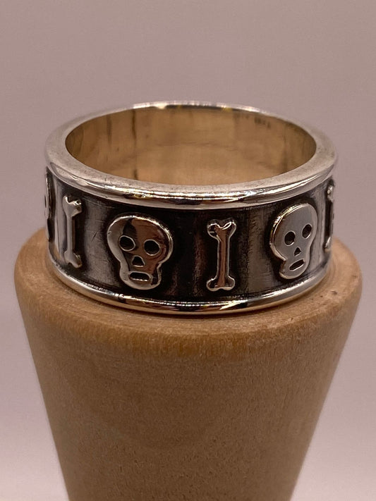 Anillo Artesanal en Plata con Calaveras y Huesos en Relieve, vista frontal