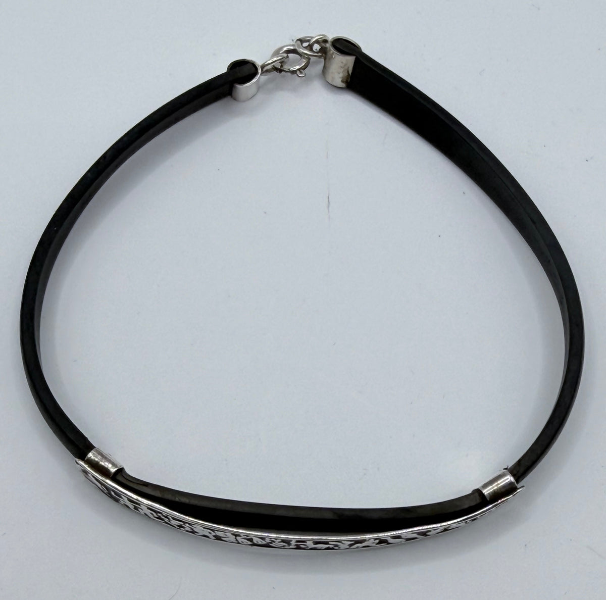 Pulsera de plata y caucho mostrando la cadena de ajuste y cierre de seguridad, diseño unisex