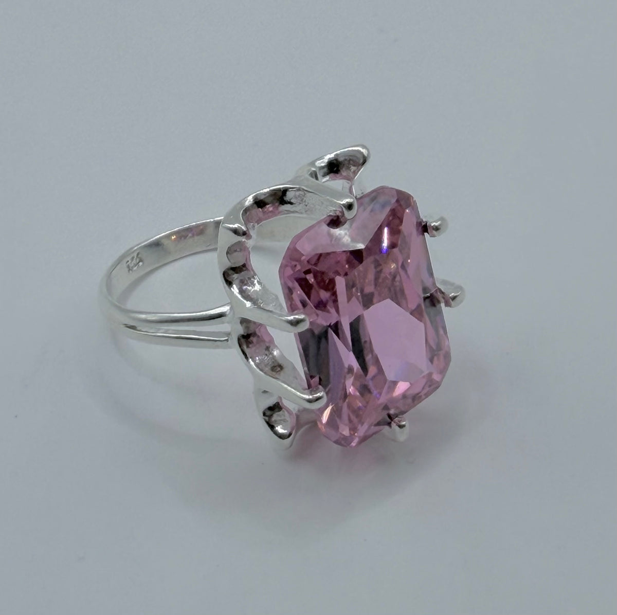 Vista frontal del anillo de circonia rosa destacando el brillo y refracción de luz de la piedra