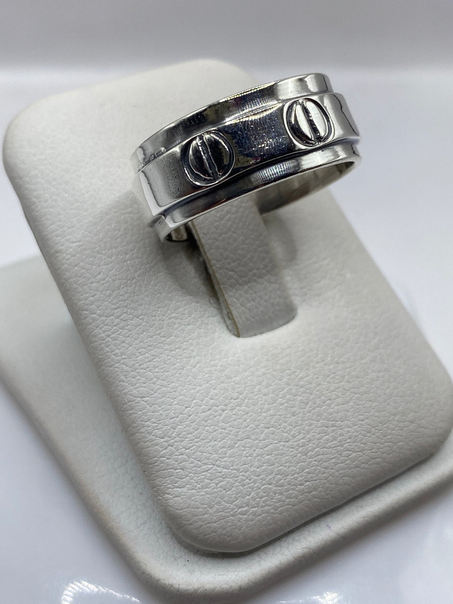 Anillo de plata en la mano de un hombre mostrando el acabado pulido y la densidad del metal