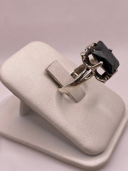 Detalle lateral del anillo de plata mostrando el engaste clásico de cuatro puntas