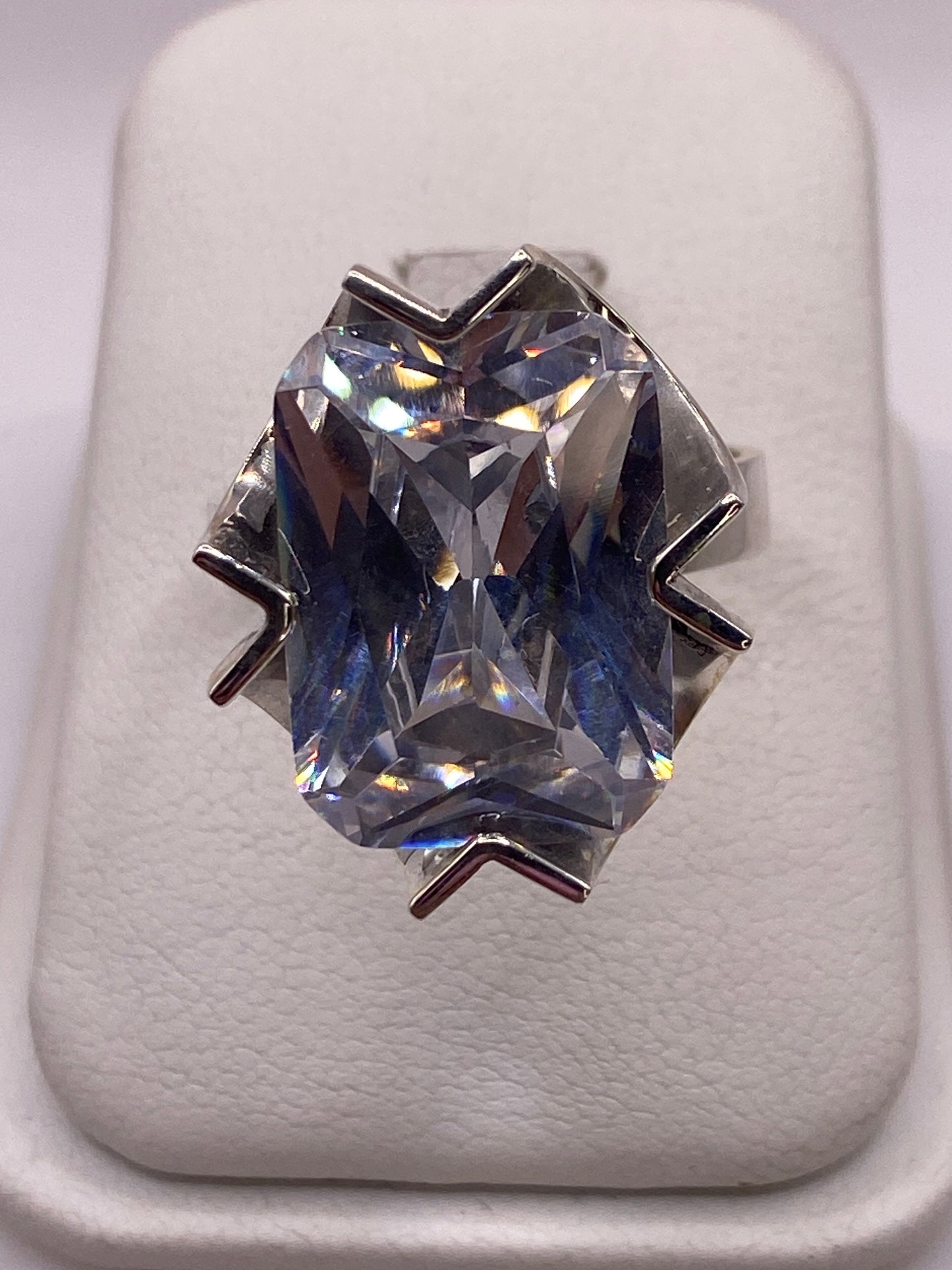 Anillo solitario de plata con circonia cristalina grande en la mano de una mujer