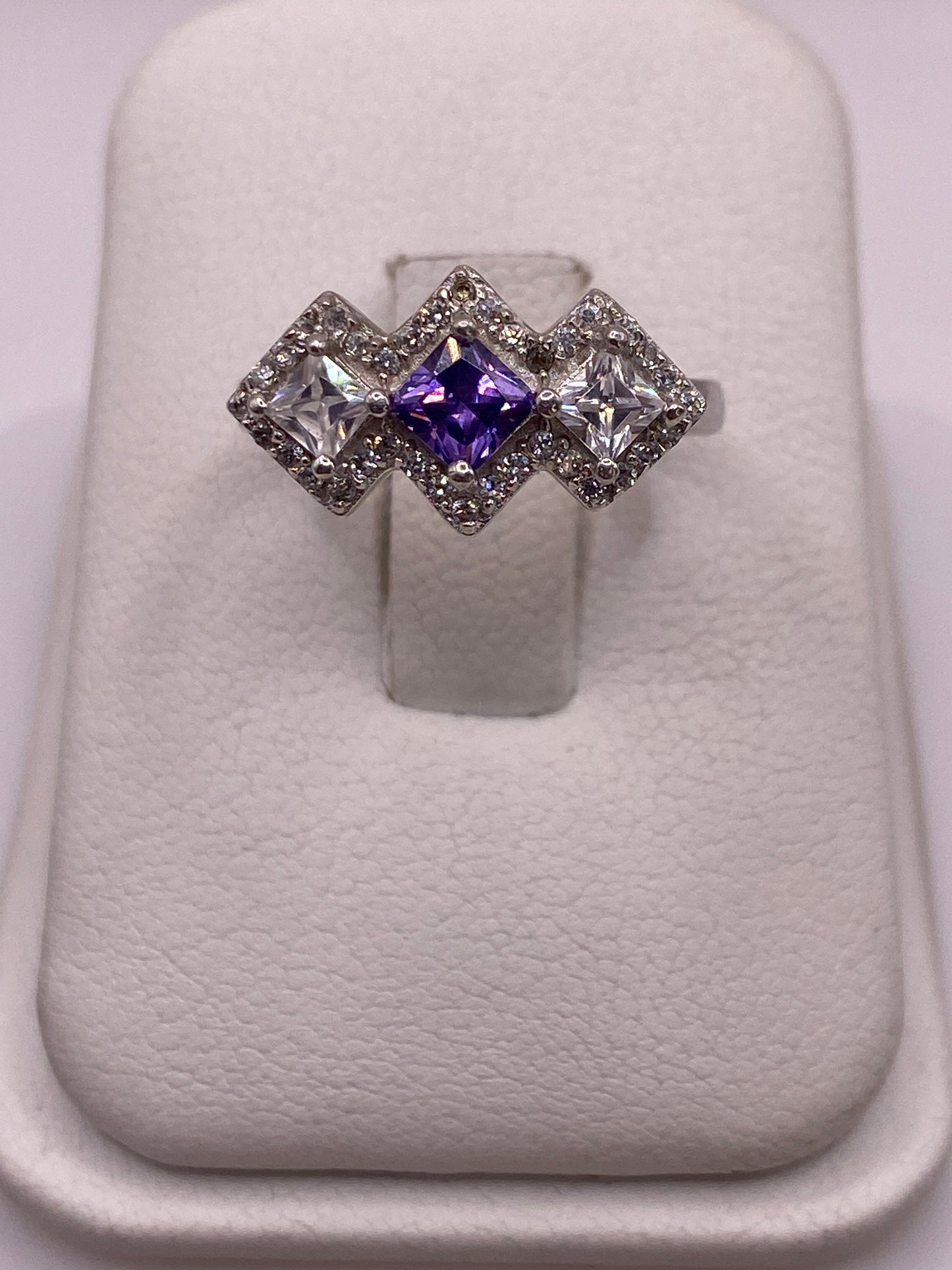 Anillo de plata .925 con tres circonias geométricas: violeta en el centro, blanca a los lados
