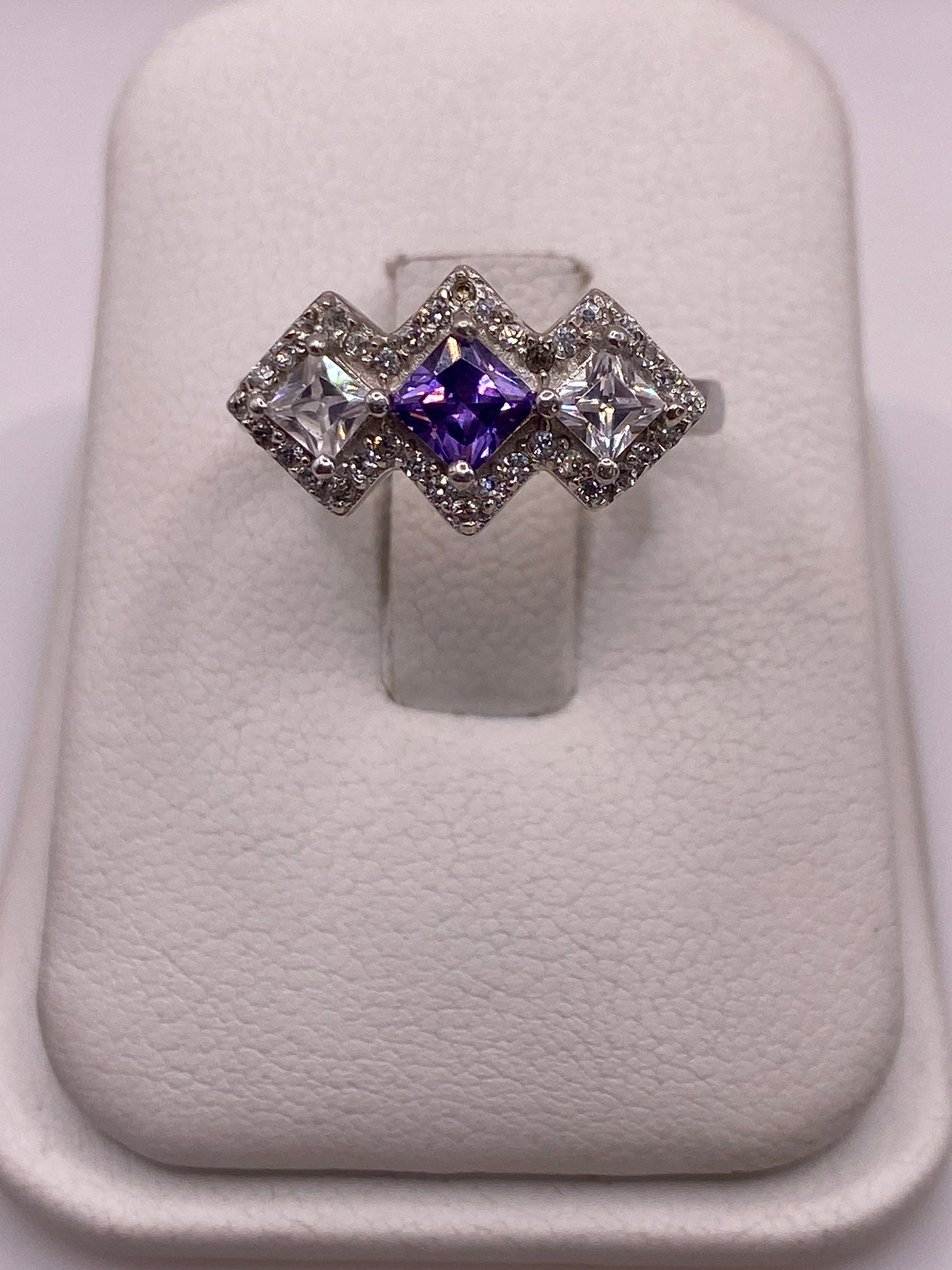 Anillo de plata .925 con tres circonias geométricas: violeta en el centro, blanca a los lados