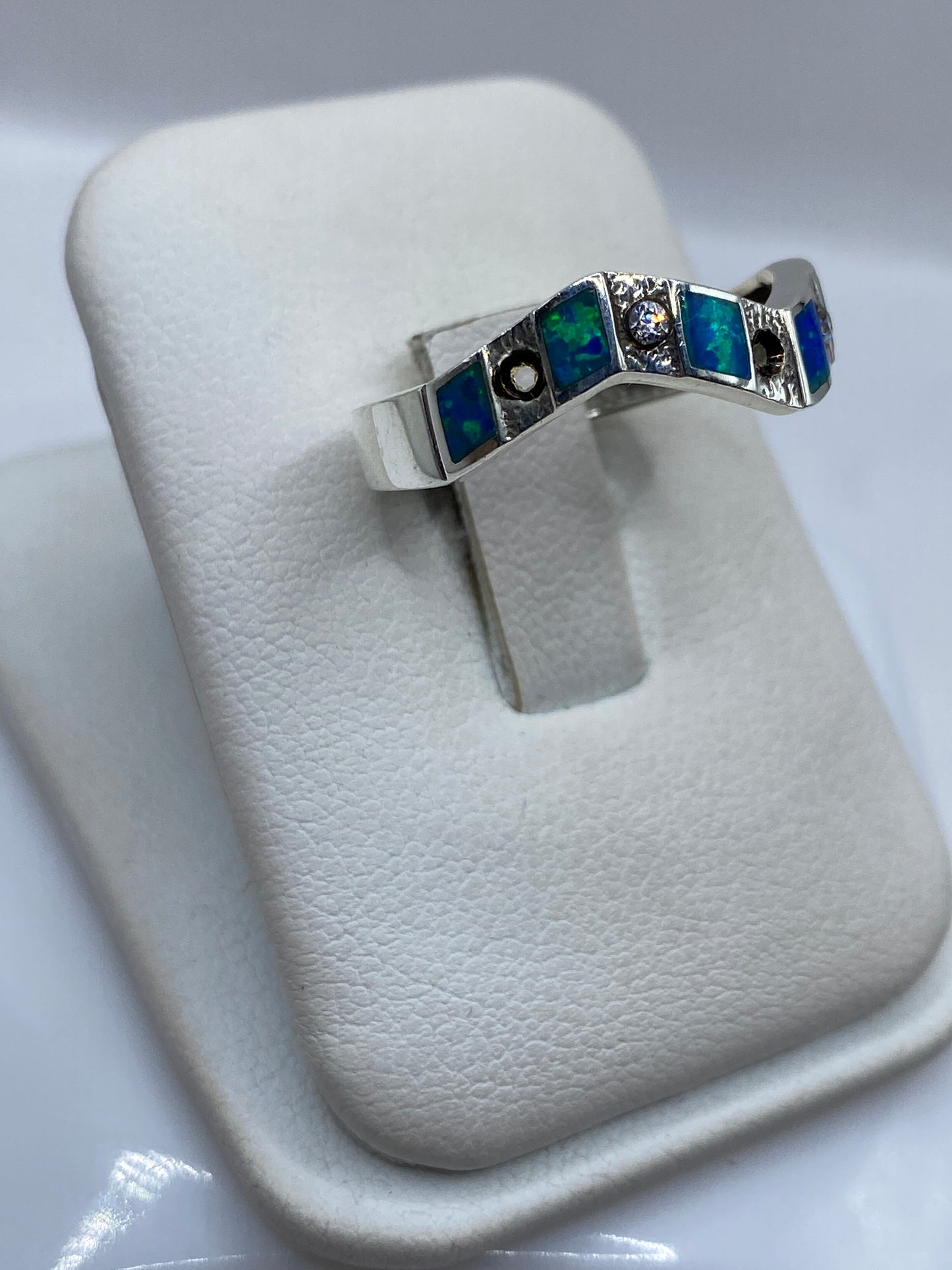 Vista lateral del anillo minimalista de plata pura .950 con ópalo azul