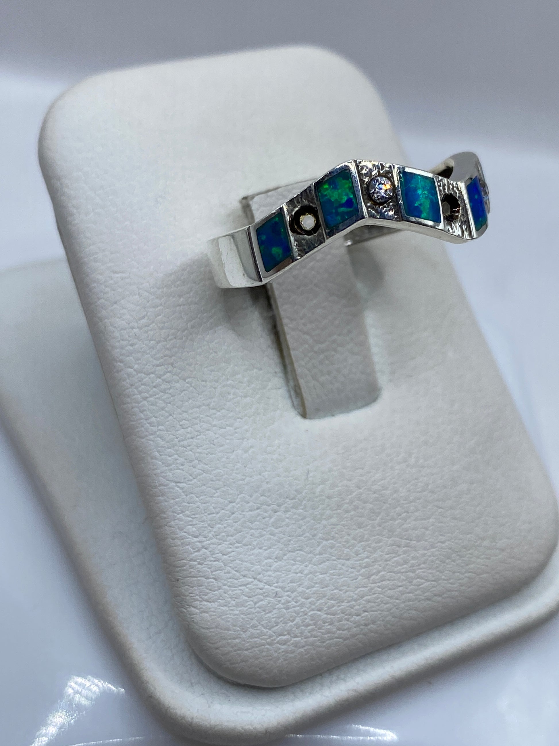 Vista lateral del anillo minimalista de plata pura .950 con ópalo azul