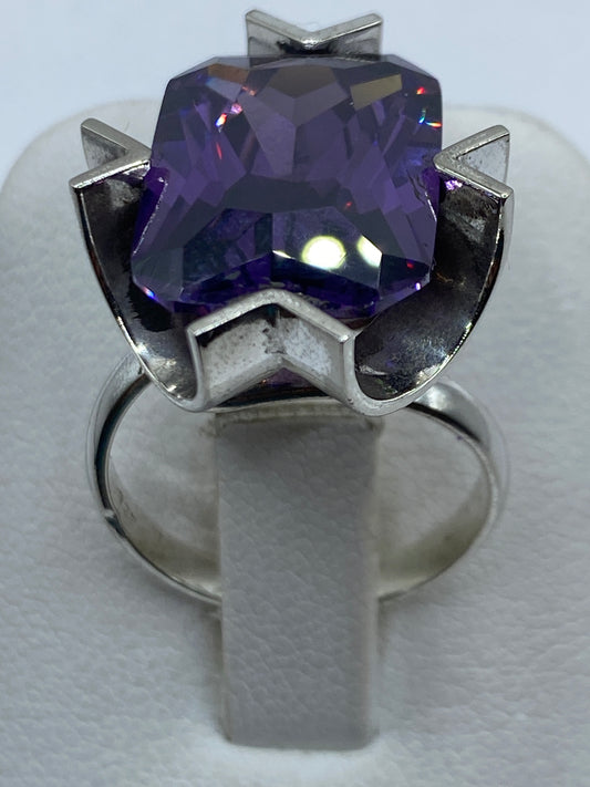 Anillo de plata con circonia morada facetada en mano de mujer, mostrando el brillo y fuego de la piedra