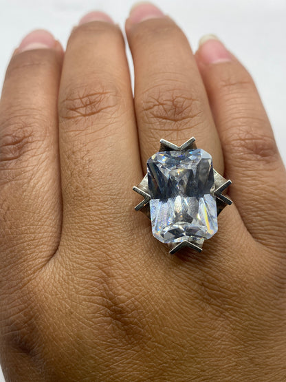 Anillo solitario brillante sobre base gris mostrando el fuego de la piedra