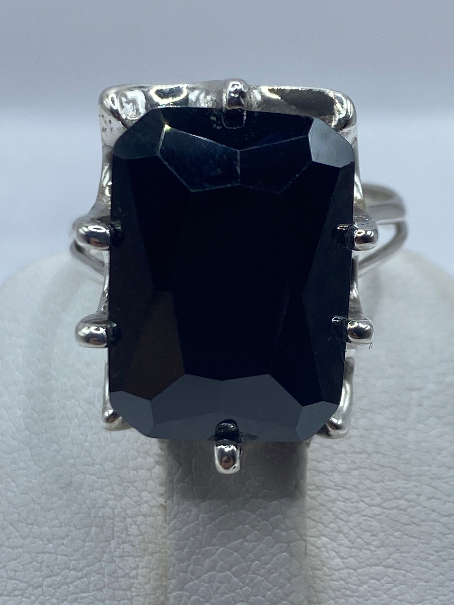 Anillo cocktail negro en la mano de una mujer mostrando brillo y facetas