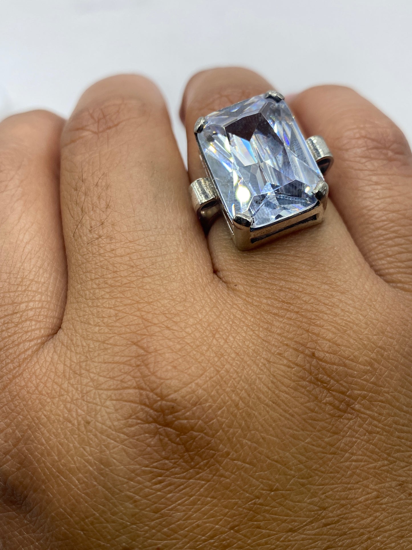 Anillo solitario en la mano mostrando el sello .925 en la banda de plata