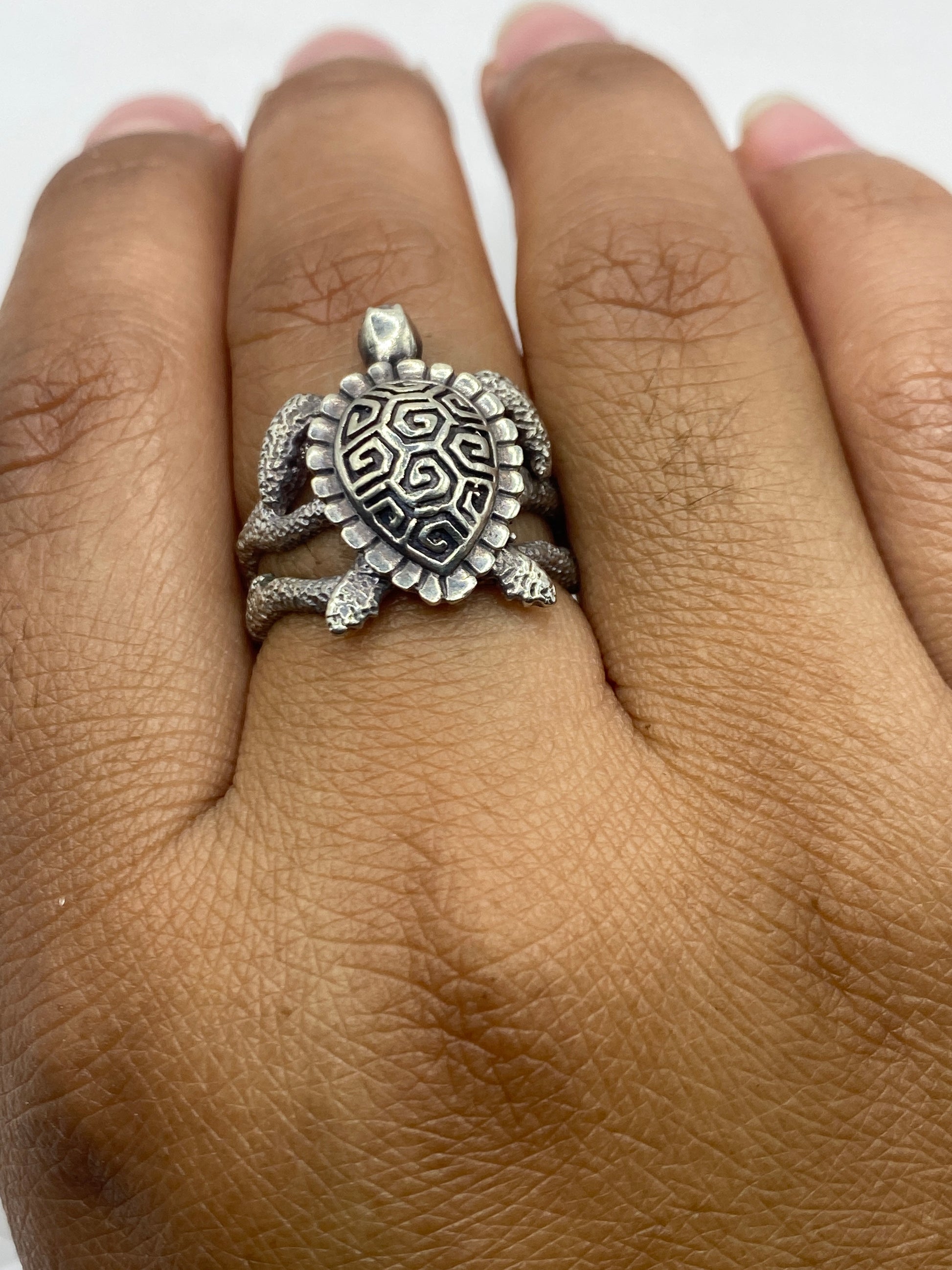 Anillo tortuga sobre fondo gris mostrando el peso 4.9 g y sello 950 auténtico