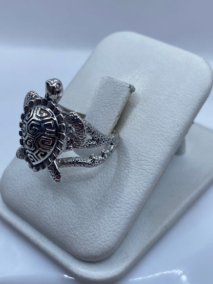 Detalle lateral del anillo mostrando textura de caparazón y banda con patrón artesanal