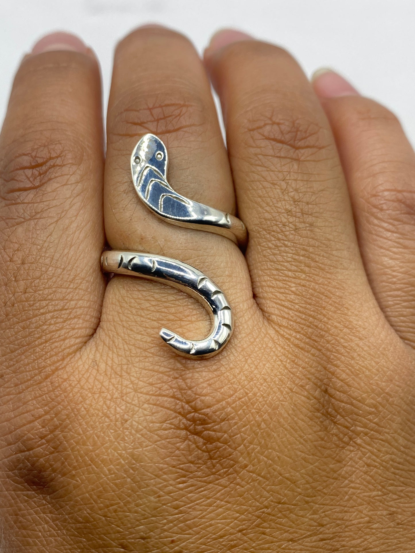 Anillo serpiente sobre fondo gris mostrando peso de 6.9 g y ajustabilidad