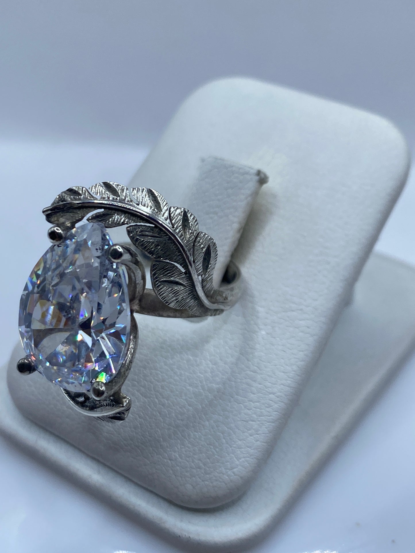 Anillo de plata con hojas artesanales talladas en relieve, detalle del engaste lateral